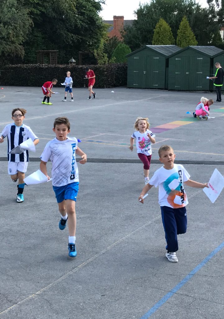 a group of kids running on a basketball court